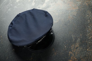 Photo of Police cap on dark table, top view. Space for text