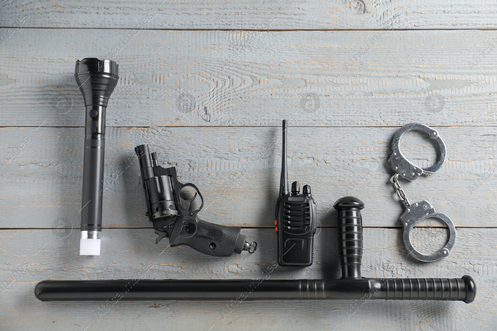 Different police equipment on grey wooden table, flat lay Photo of Different police equipment on grey wooden table, flat lay