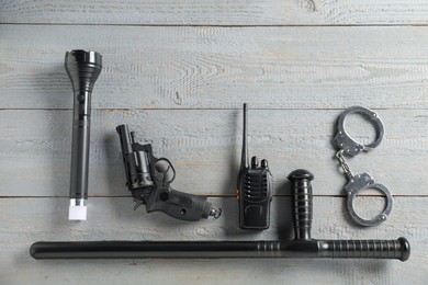 Photo of Different police equipment on grey wooden table, flat lay