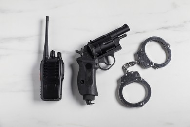 Photo of Different police equipment on white marble table, flat lay