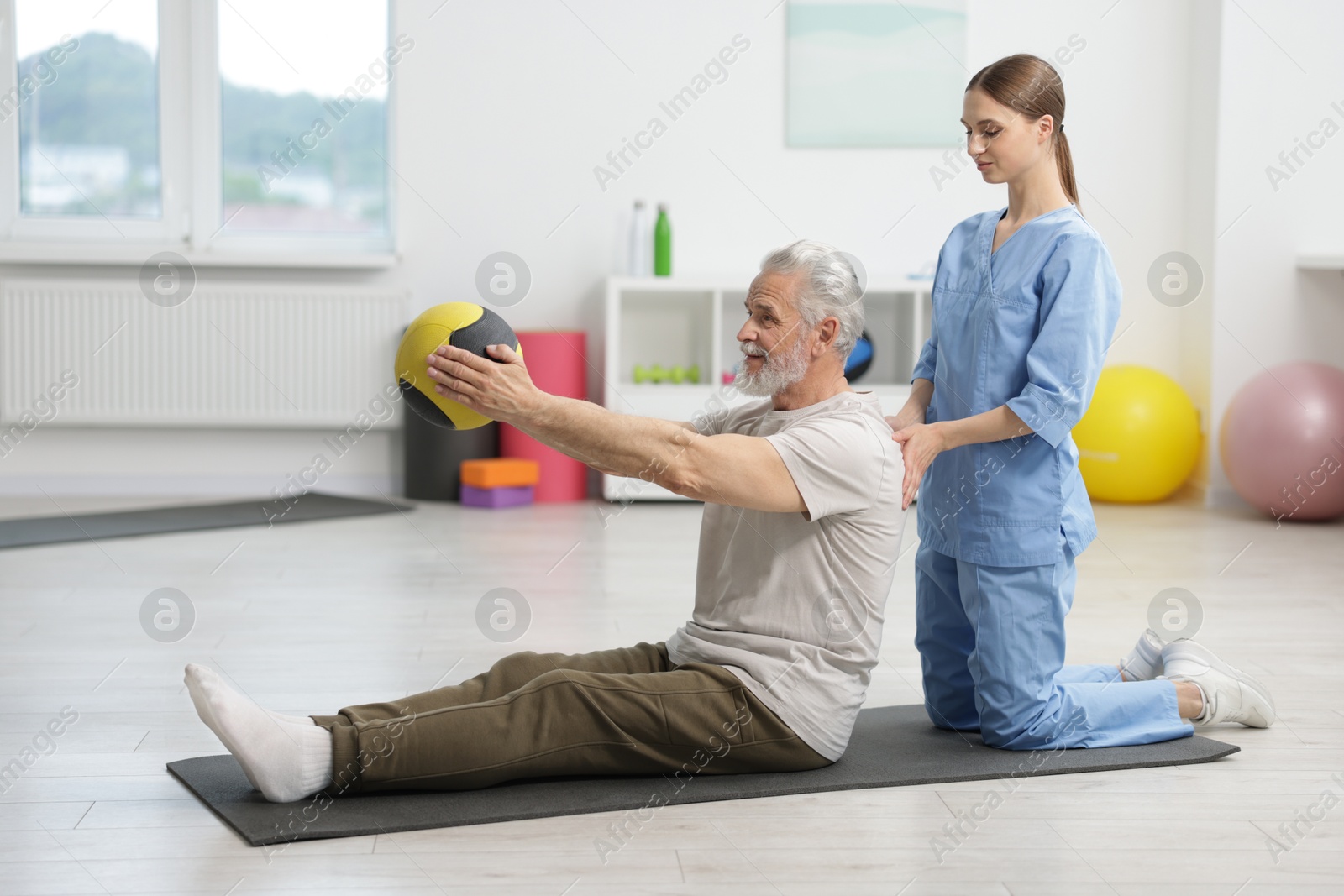 Doctor and patient exercising with medicine ball in clinic Photo of Doctor and patient exercising with medicine ball in clinic