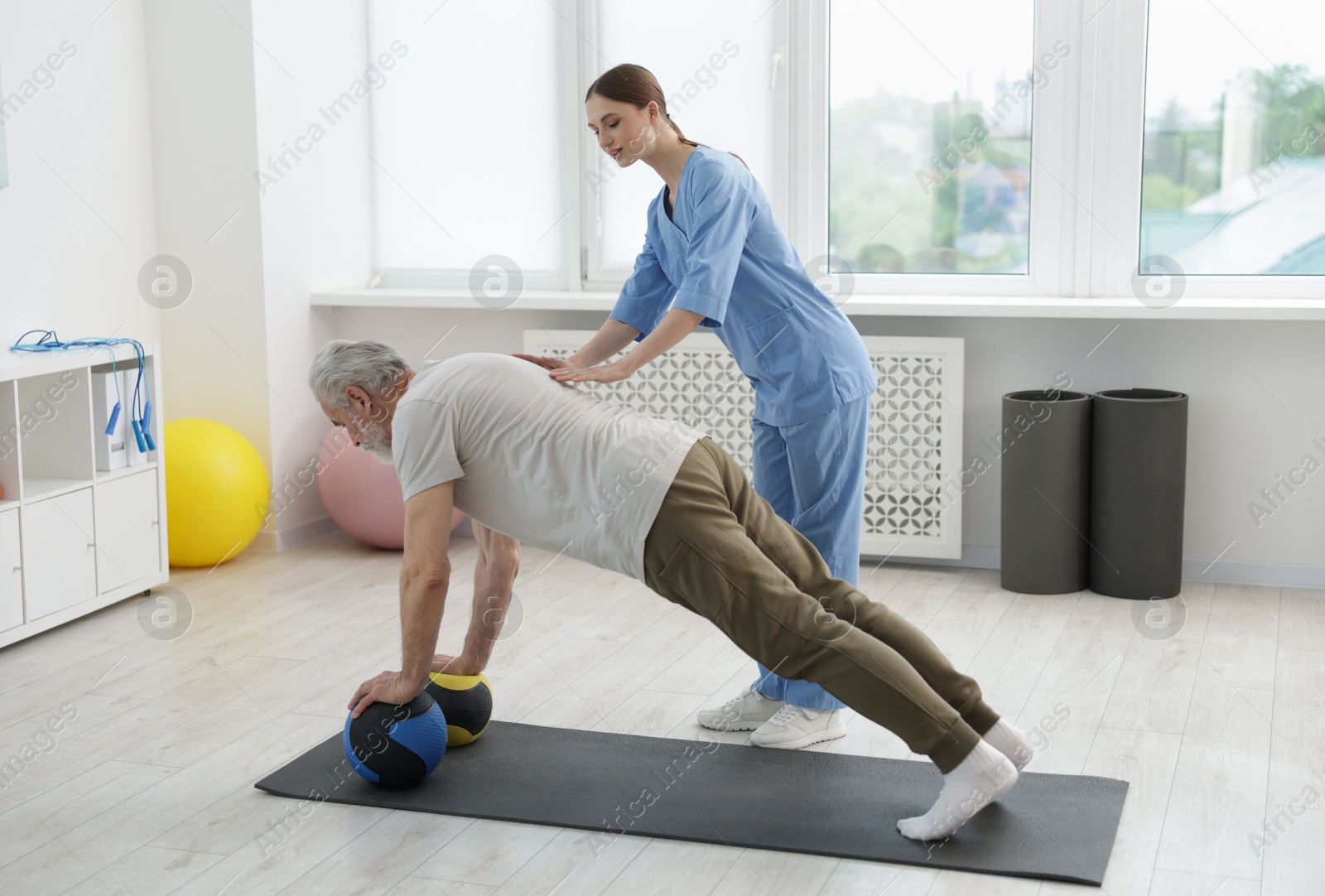 Doctor and patient exercising with medicine ball in clinic Photo of Doctor and patient exercising with medicine ball in clinic