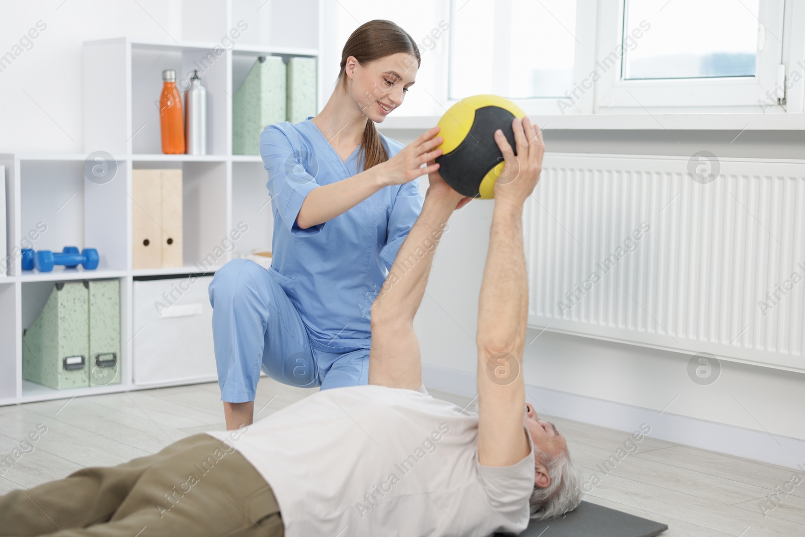 Doctor and patient exercising with medicine ball in clinic Photo of Doctor and patient exercising with medicine ball in clinic