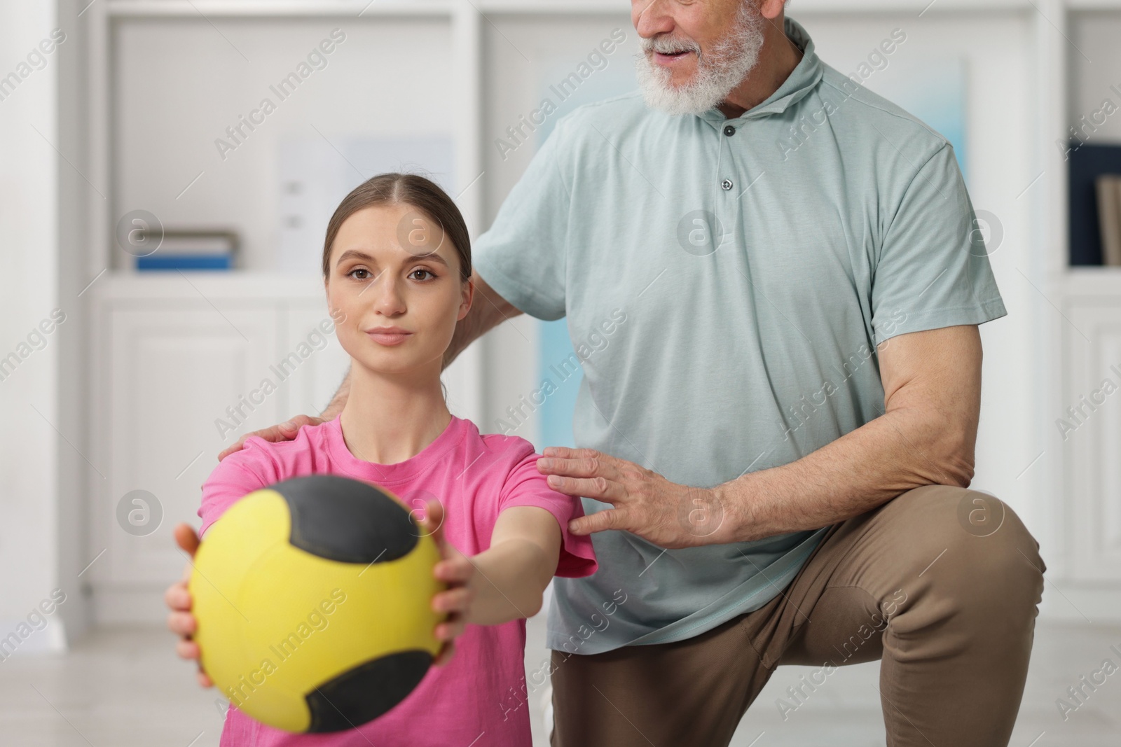 Doctor and patient exercising with medicine ball in clinic Photo of Doctor and patient exercising with medicine ball in clinic