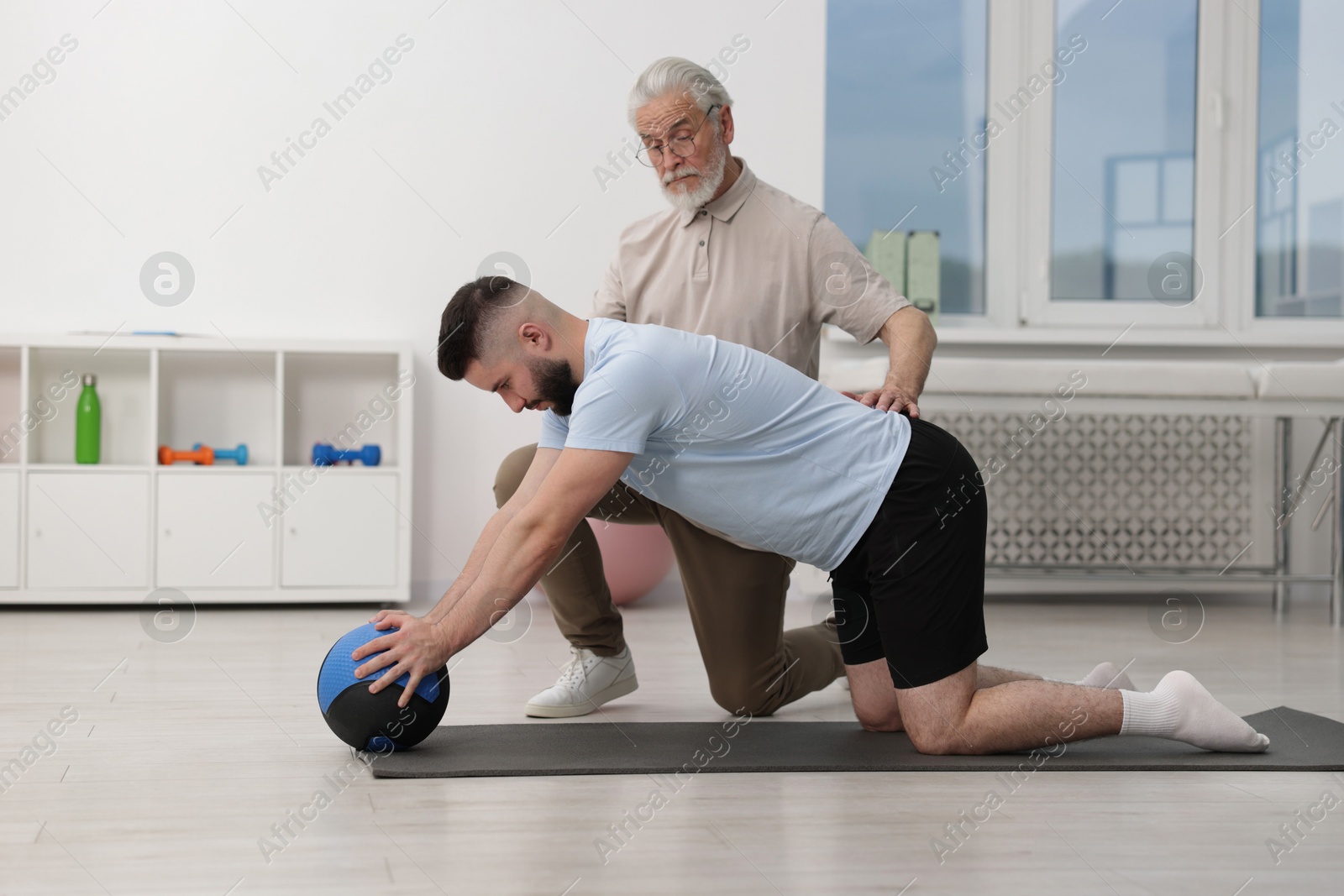 Doctor and patient exercising with medicine ball in clinic Photo of Doctor and patient exercising with medicine ball in clinic