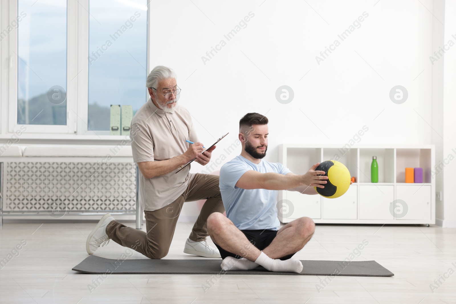 Doctor and patient exercising with medicine ball in clinic Photo of Doctor and patient exercising with medicine ball in clinic