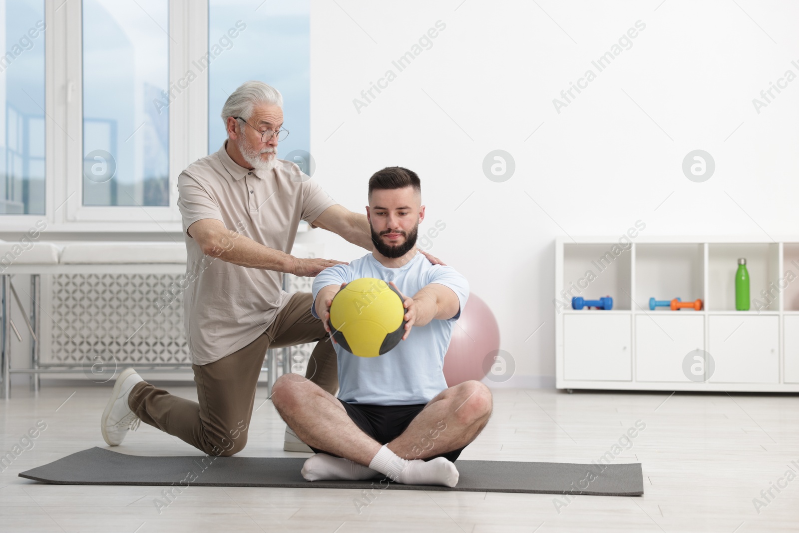 Doctor and patient exercising with medicine ball in clinic Photo of Doctor and patient exercising with medicine ball in clinic