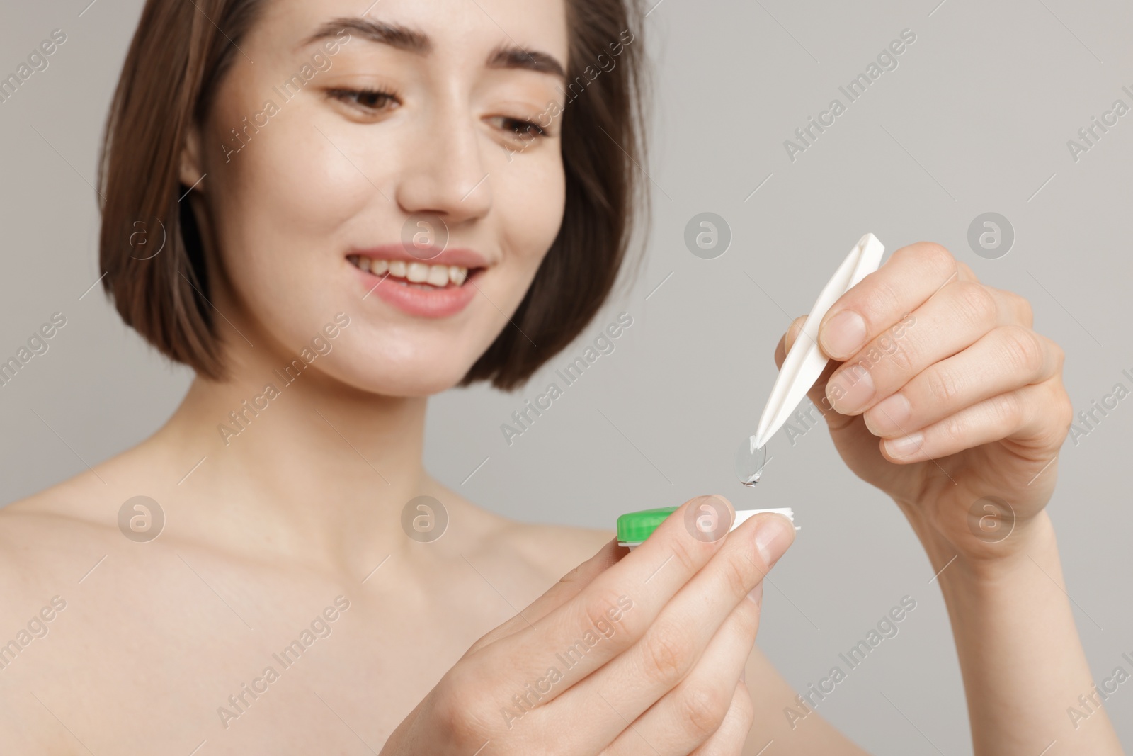 Woman taking contact lens out of case on light background, closeup Photo of Woman taking contact lens out of case on light background, closeup
