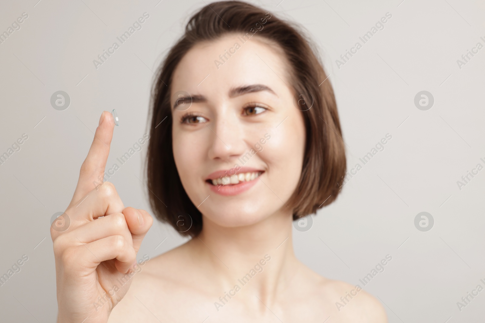 Woman with contact lens on light background Photo of Woman with contact lens on light background