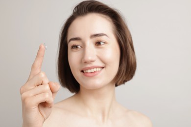 Photo of Woman with contact lens on light background