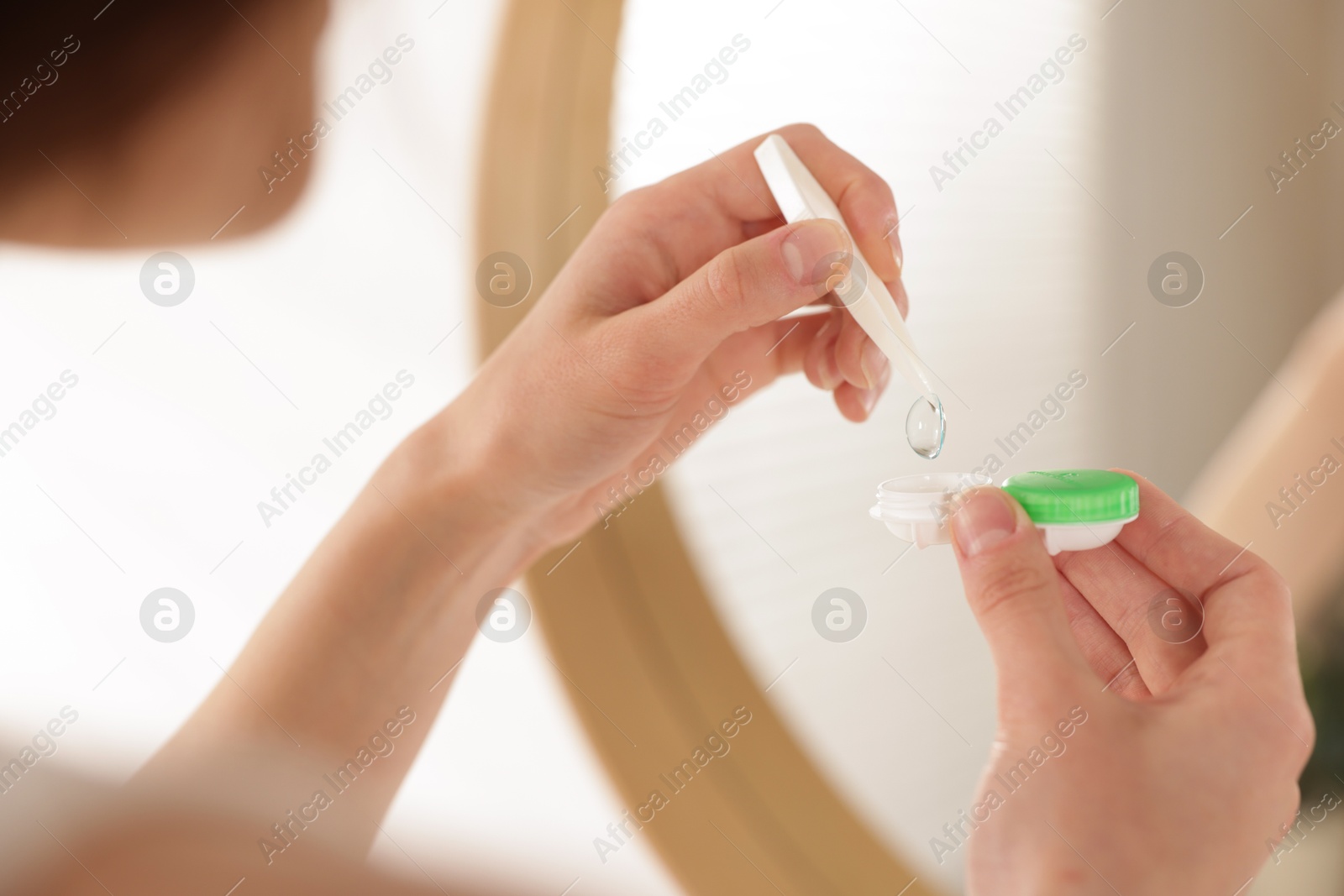 Woman taking contact lens out of case indoors, closeup Photo of Woman taking contact lens out of case indoors, closeup
