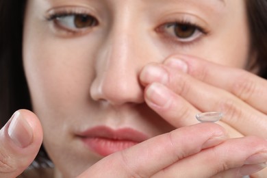 Photo of Beautiful woman putting in contact lens, closeup