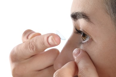 Photo of Woman putting in contact lens on white background, closeup