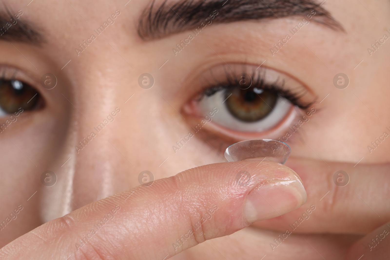 Beautiful woman putting in contact lens, closeup Photo of Beautiful woman putting in contact lens, closeup