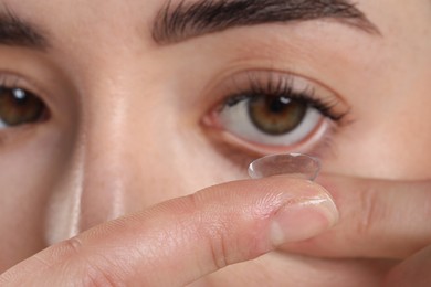 Photo of Beautiful woman putting in contact lens, closeup