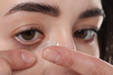 Photo of Beautiful woman putting in contact lens, closeup