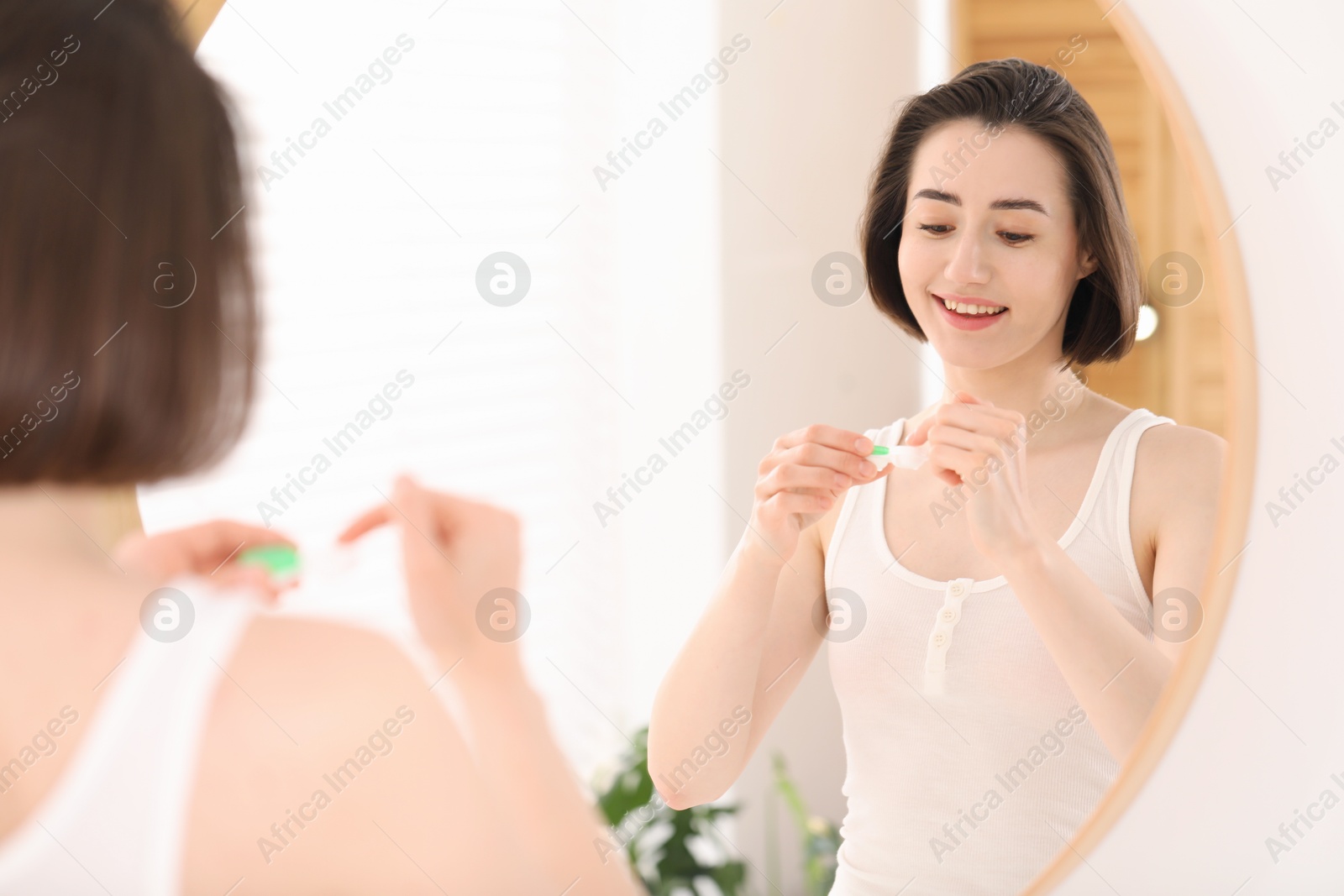 Woman taking contact lens out of case indoors Photo of Woman taking contact lens out of case indoors