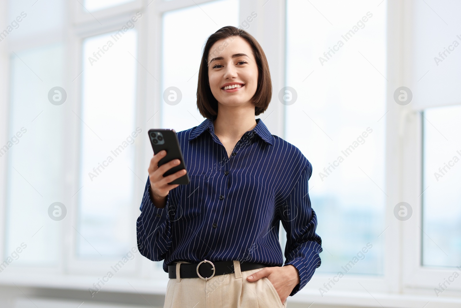 Beautiful woman using her smartphone in office Photo of Beautiful woman using her smartphone in office