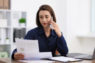 Photo of Beautiful woman talking on phone at desk in office