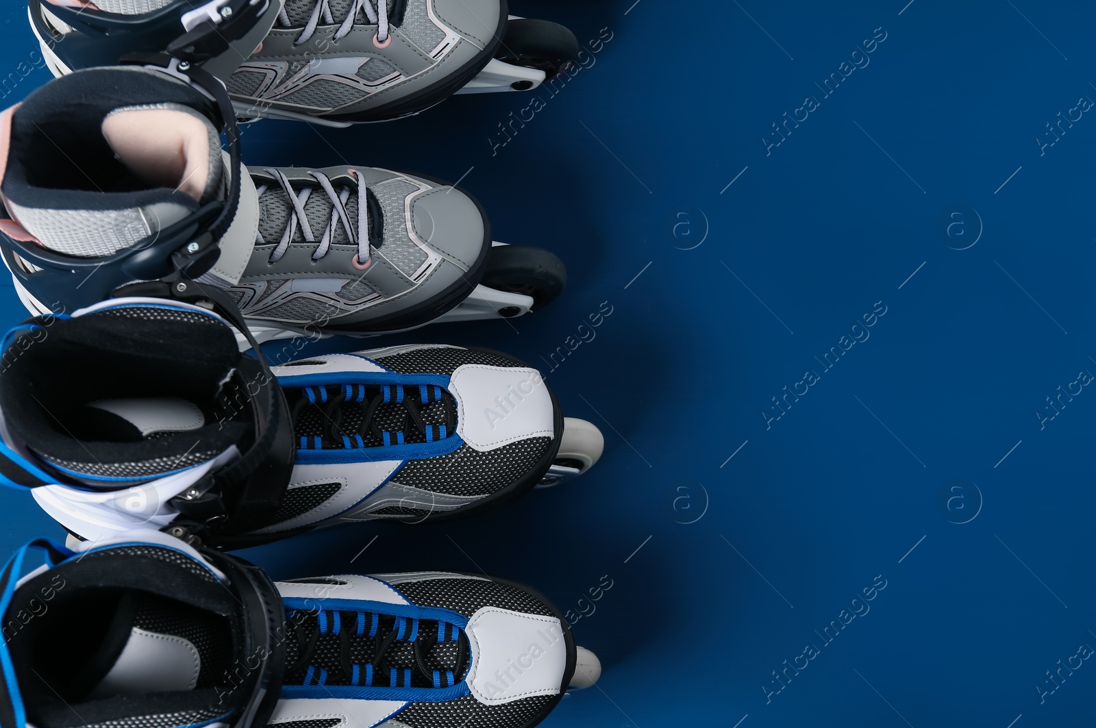 Photo of Roller skates on blue background, flat lay. Space for text