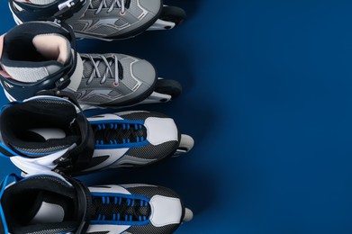 Photo of Roller skates on blue background, flat lay. Space for text