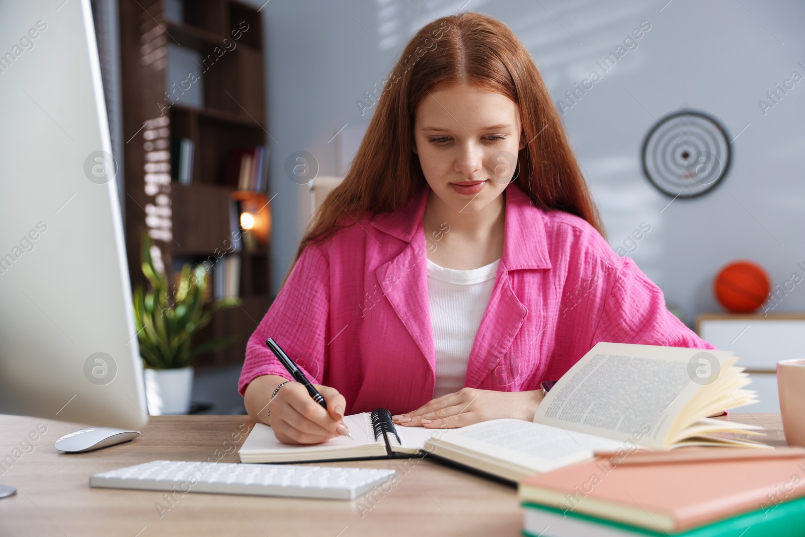 Teenage student taking notes while studying at table indoors Photo of Teenage student taking notes while studying at table indoors
