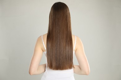 Photo of Woman with perfect long hair on light background, back view