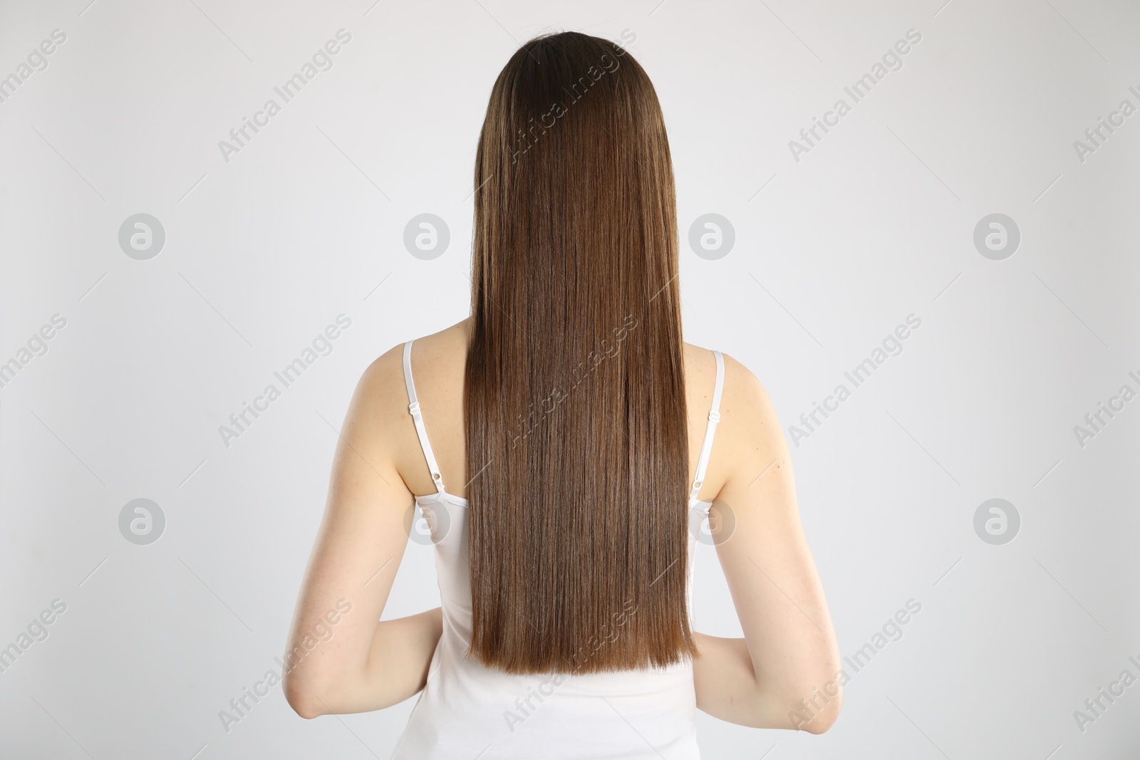 Photo of Woman with perfect long hair on light background, back view