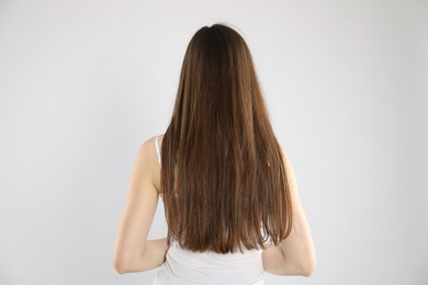 Photo of Woman with long hair on light background, back view