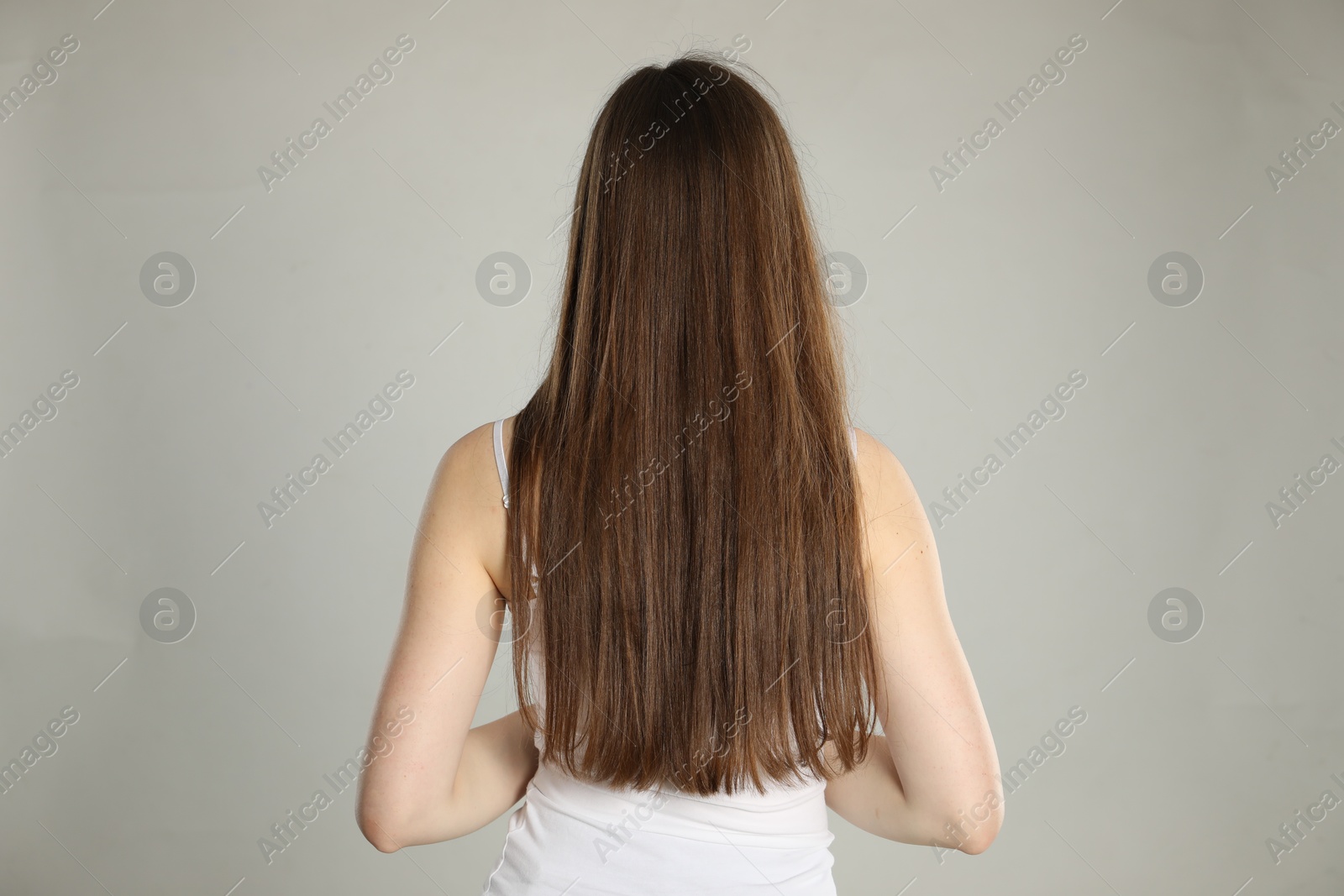 Photo of Woman with long hair on light background, back view