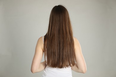 Photo of Woman with long hair on light background, back view