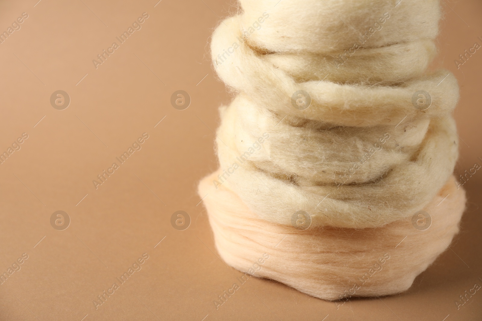 Natural felting wool on brown background, closeup. Space for text Photo of Natural felting wool on brown background, closeup. Space for text