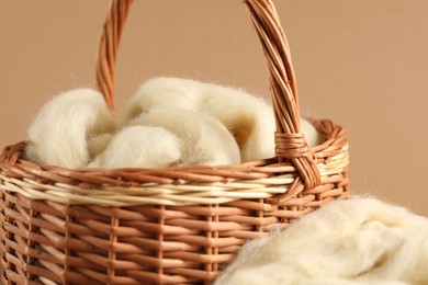 Photo of Felting wool in basket on brown background, closeup