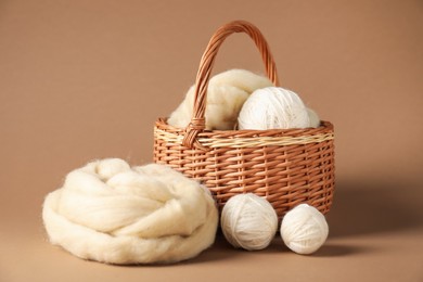 Photo of Felting wool and knitting yarn on brown background