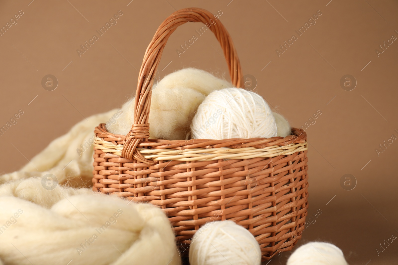 Felting wool and knitting yarn on brown background, closeup Photo of Felting wool and knitting yarn on brown background, closeup