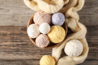 Photo of Felting wool and knitting yarn on wooden table, top view