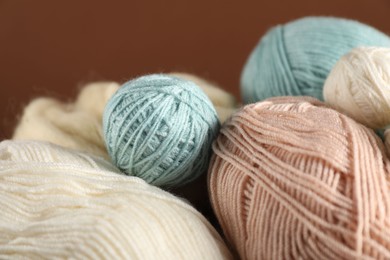 Photo of Colorful knitting yarn on brown background, closeup