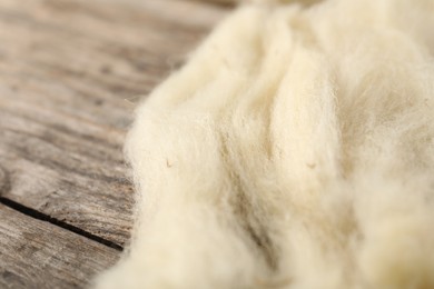 Photo of Natural felting wool on wooden background, closeup