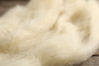Photo of Natural felting wool on wooden background, closeup