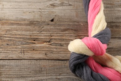 Photo of Colorful felting wool on wooden background, top view. Space for text