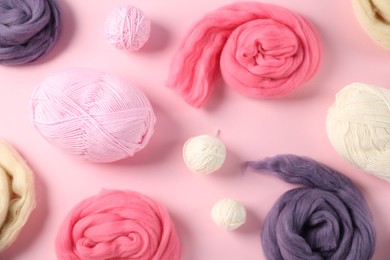Photo of Felting wool and knitting yarn on pink background, flat lay