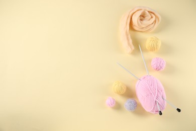 Photo of Felting wool and knitting yarn with needles on beige background, flat lay. Space for text