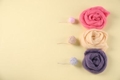Photo of Felting wool and knitting yarn on beige background, flat lay. Space for text