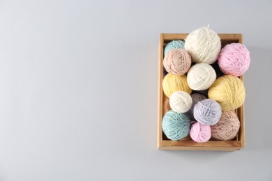 Photo of Colorful knitting yarn on light background, top view. Space for text