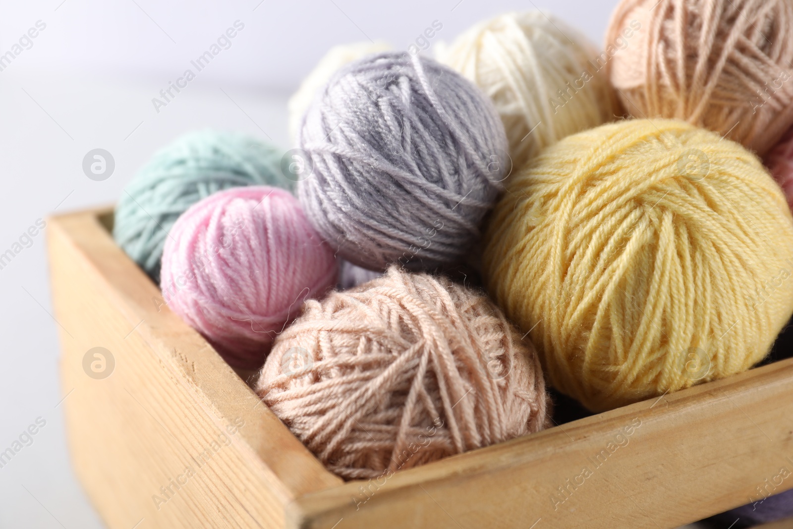Photo of Colorful knitting yarn on light background, closeup