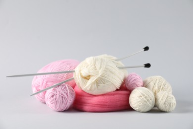 Photo of Felting wool and knitting yarn with needles on light background. Space for text