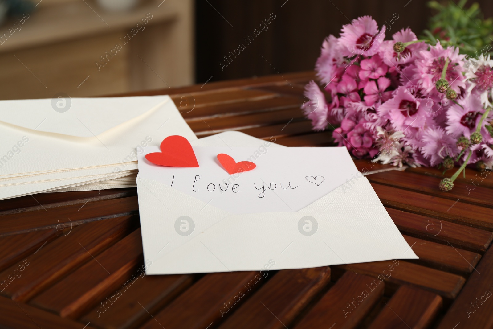 Card with phrase I Love You, letters, red hearts and flowers on wooden table indoors, closeup Photo of Card with phrase I Love You, letters, red hearts and flowers on wooden table indoors, closeup