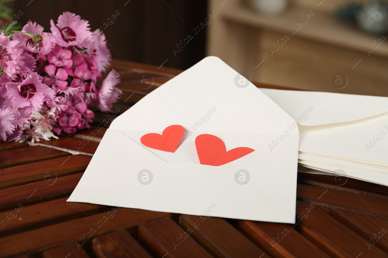 Love letters, red hearts and flowers on wooden table indoors, closeup Photo of Love letters, red hearts and flowers on wooden table indoors, closeup