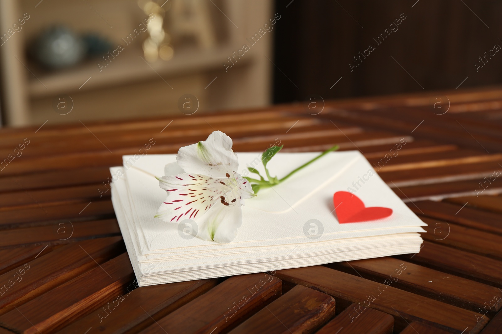 Stack of love letters, red heart and flower on wooden table indoors, closeup Photo of Stack of love letters, red heart and flower on wooden table indoors, closeup