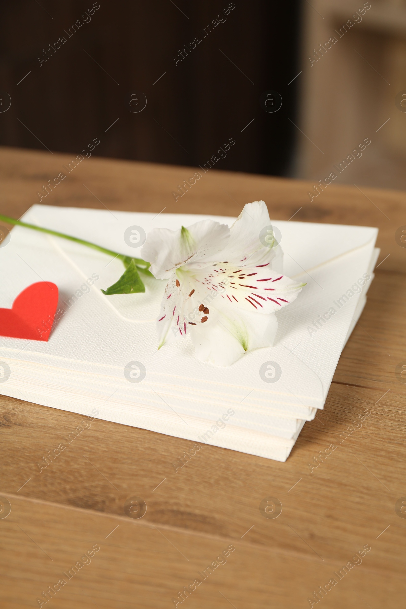Stack of love letters, red heart and flower on wooden table indoors, closeup Photo of Stack of love letters, red heart and flower on wooden table indoors, closeup